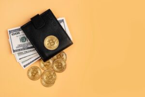wallet with dollar bills and physical bitcoins around